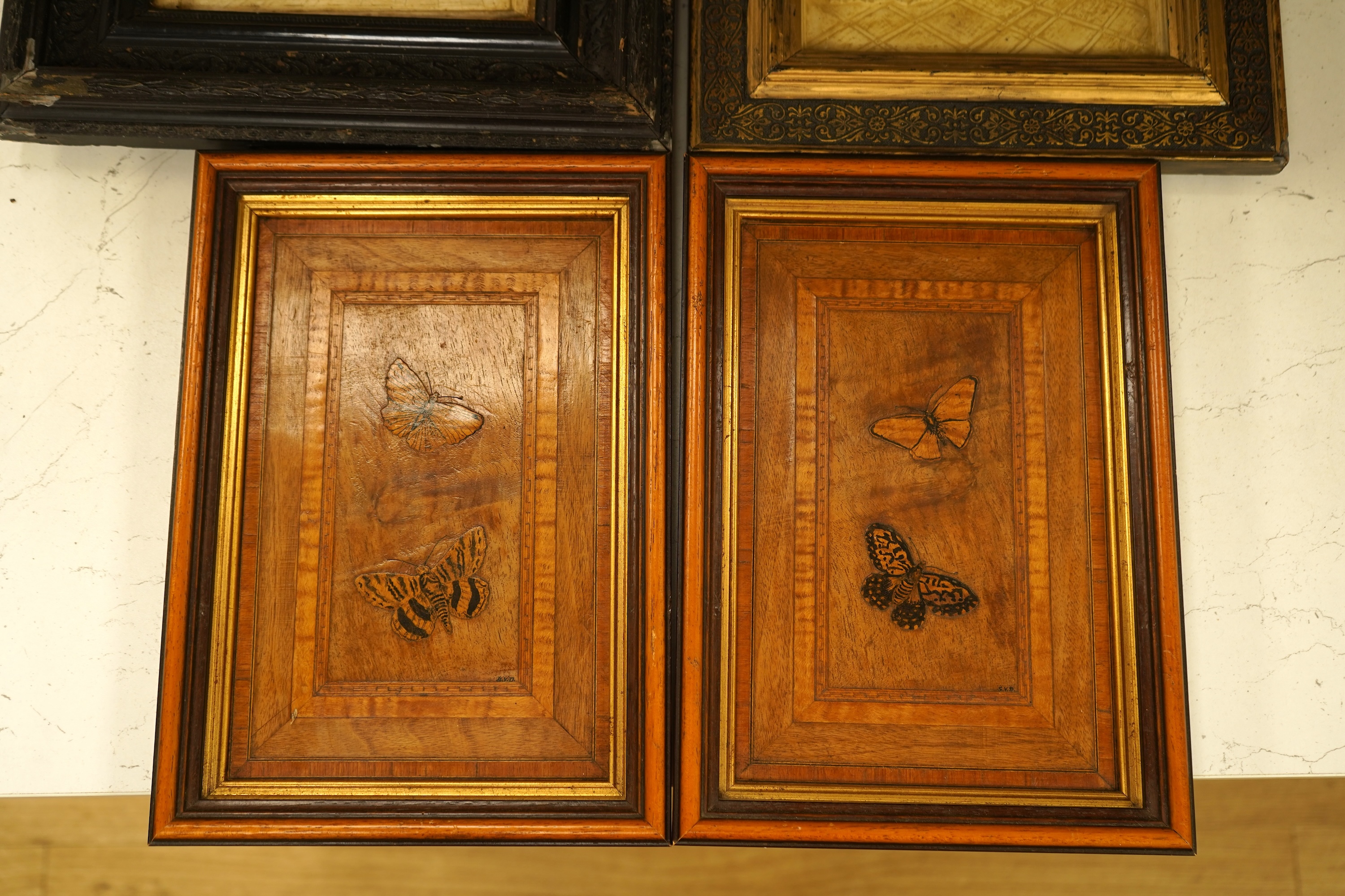 SVD., a pair of marquetry and penwork butterfly panels and a pair of relief moulded plaster panels depicting Tudor scenes, each framed, largest 41cm high